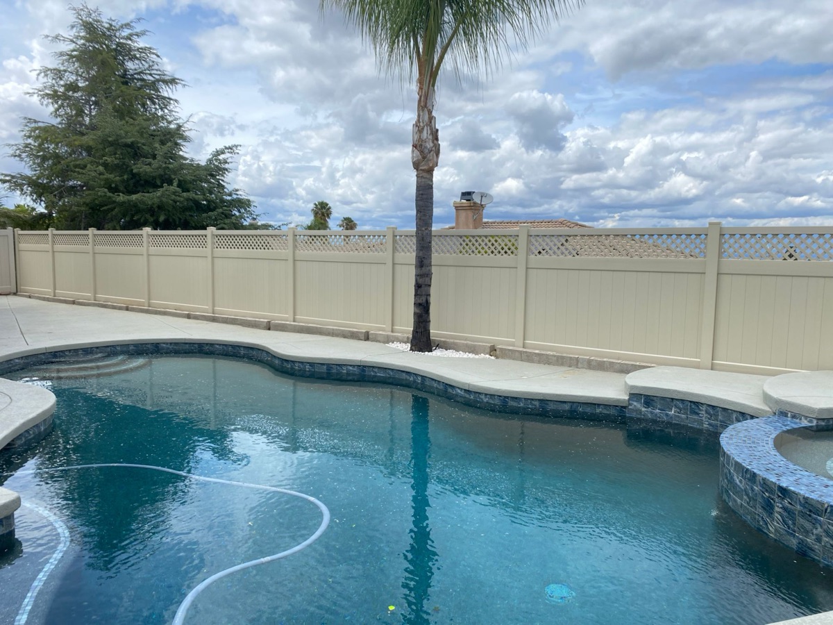 Vinyl privacy fence with lattice top around pool